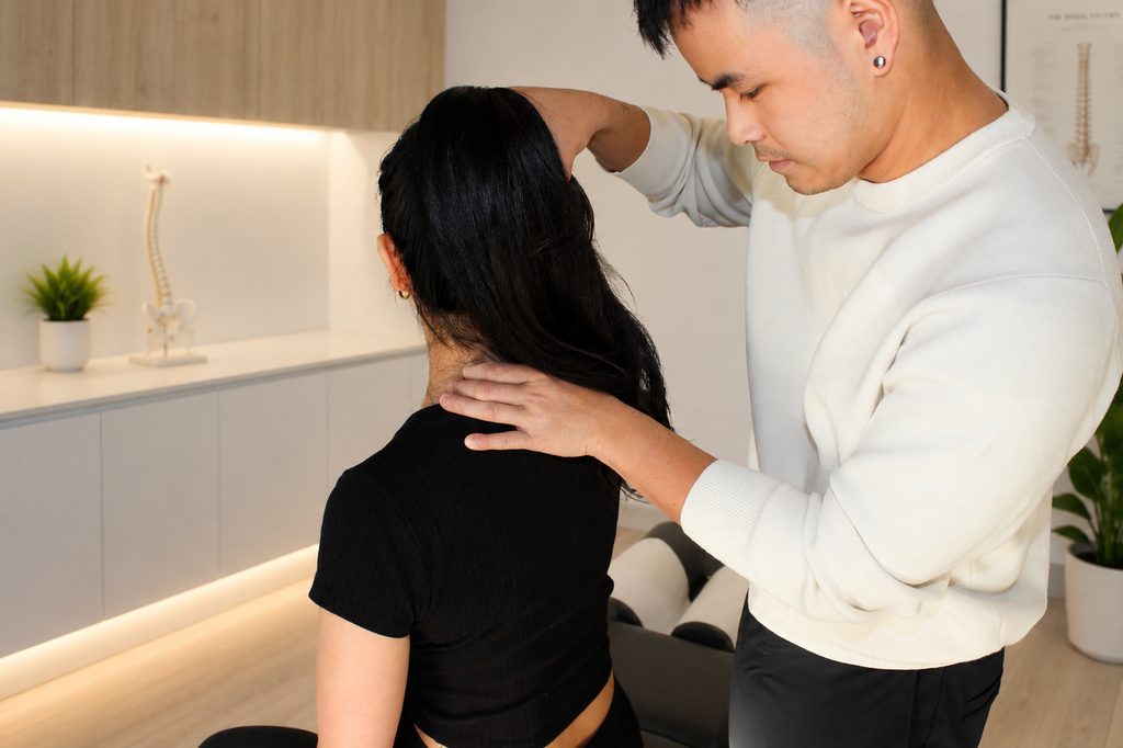 Initial Chiropractic Consultation | APEX. Chiro Gregory Hills Chiropractor performing a spinal assessment with a patient at APEX. Chiro Gregory Hills.